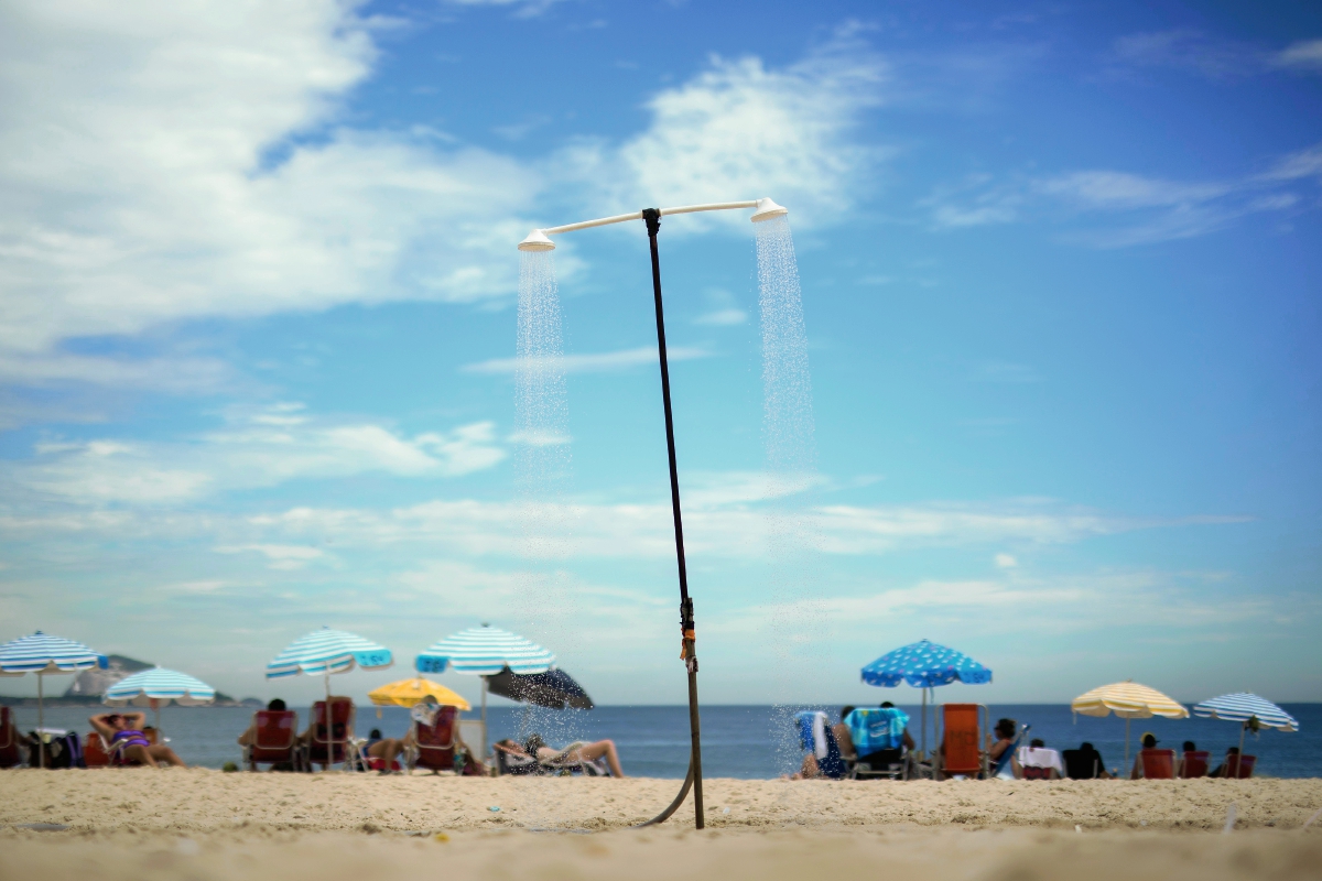 Una ducha de manera permanente está disponible con agua para los visitantes a la playa de Copacabana, Brasil, sin embargo la sequía amenaza con limitar esos recursos para los brasileños. (Foto Prensa Libre: AP).