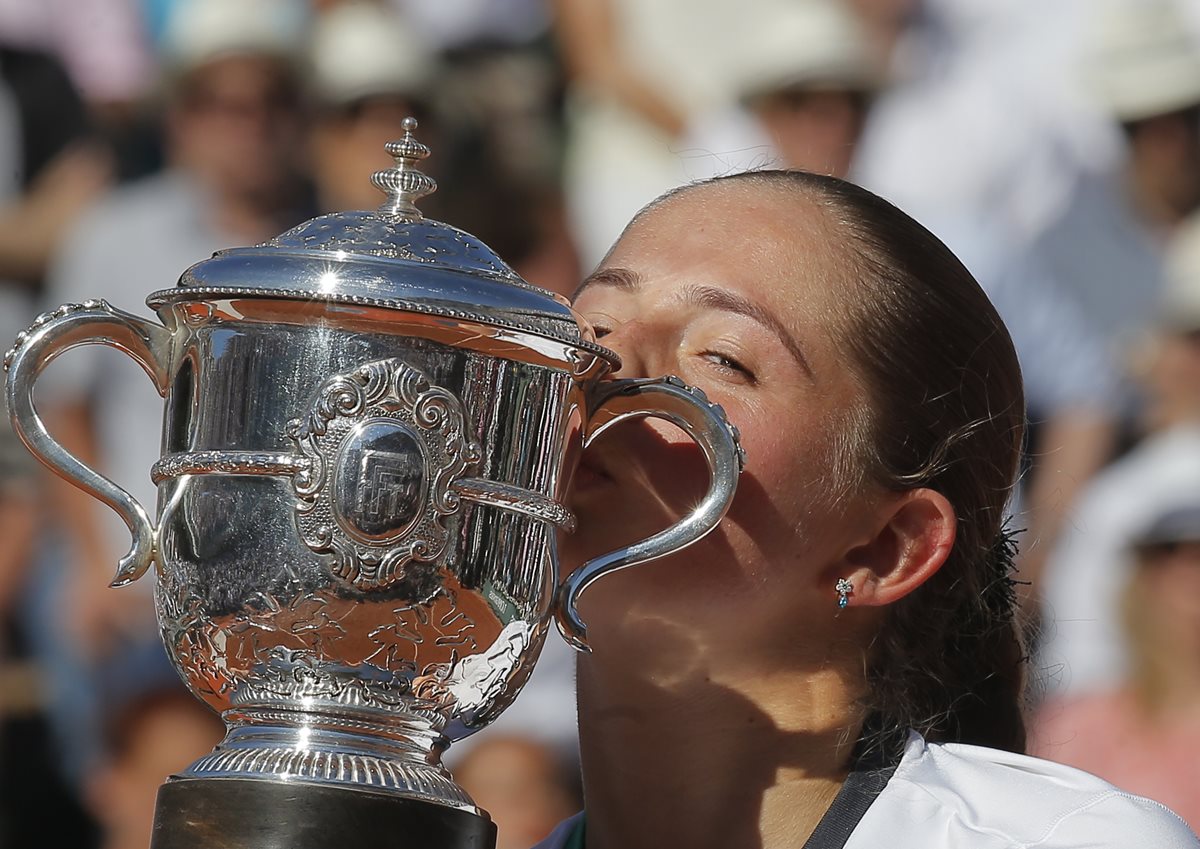 Jelena Ostapenko besa con mucha emoción el trofeo que la convierte en la nueva reina del Roland Garros. (Foto Prensa Libre: AP)