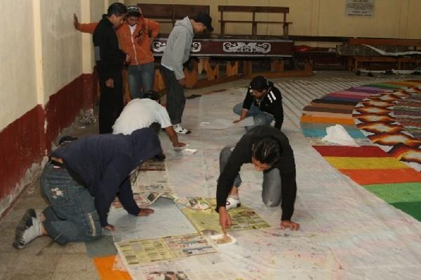 grupos de jóvenes trabajan en casas y salones comunales en el diseño de los barriletes.