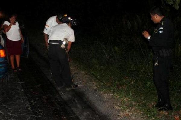 Bomberos y policías observan el lugar donde murió arrollado el motorista. (Foto Prensa Libre: Melvin Sandoval)<br _mce_bogus="1"/>