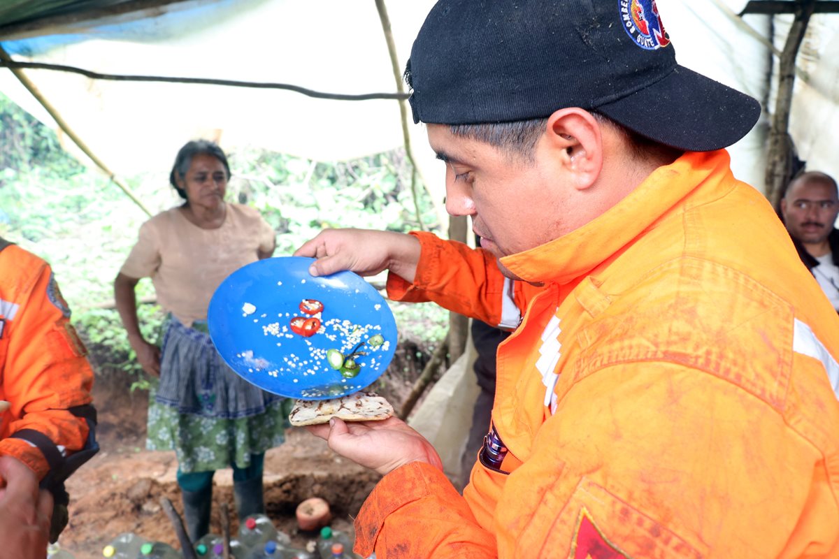 Un socorrista se alimenta con lo que recibió de una familia de campesinos. Foto Prensa Libre: Renato Melgar.