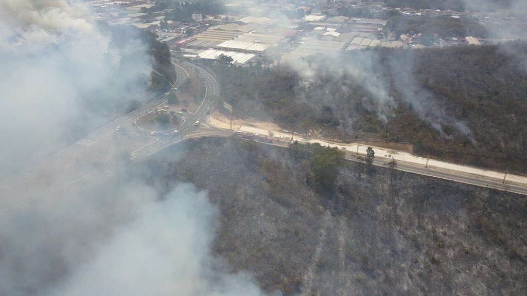 Vista aérea del incendio sobre terrenos cercanos al bulevar El Naranjo. (Foto Prensa Libre: Conred)