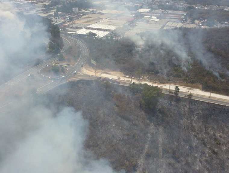 Vista aérea del incendio sobre terrenos cercanos al bulevar El Naranjo. (Foto Prensa Libre: Conred)
