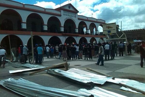 Vecinos junto a unas de las láminas que fueron quitadas donde se pretende construir la Plaza Cívica, en Chimaltenango. (Foto Prensa Libre: Víctor Chamalé)<br _mce_bogus="1"/>