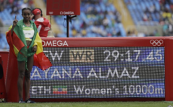 Almaz Ayana posa junto a la pantalla donde se muestra su récord logrado en los 10,000 metros planos. (Foto Prensa Libre: AP)