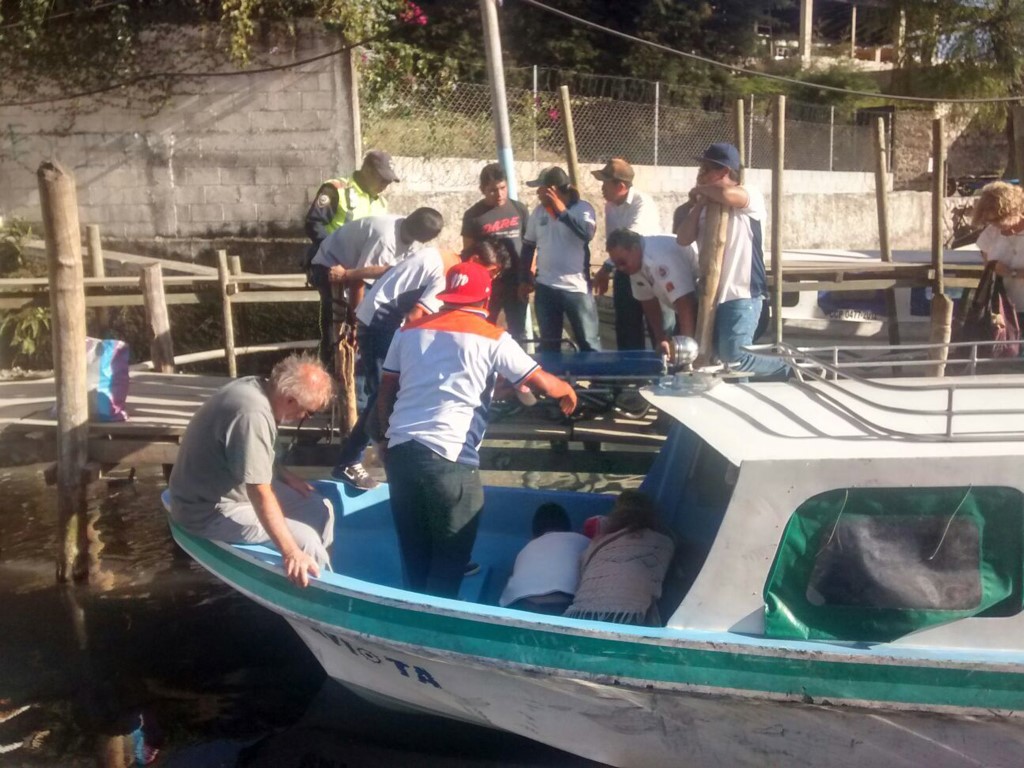Socorristas voluntarios atienden a turista en muelle de Panajachel, Sololá. (Foto Prensa Libre: Ángel Julajuj)