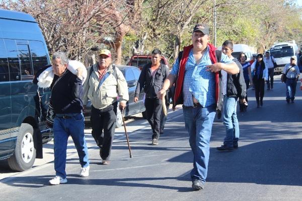 Viajeros caminan entre  vehículos parados, debido a la protesta efectuada en ruta Interamericana. (Foto Prensa Libre: Óscar González)