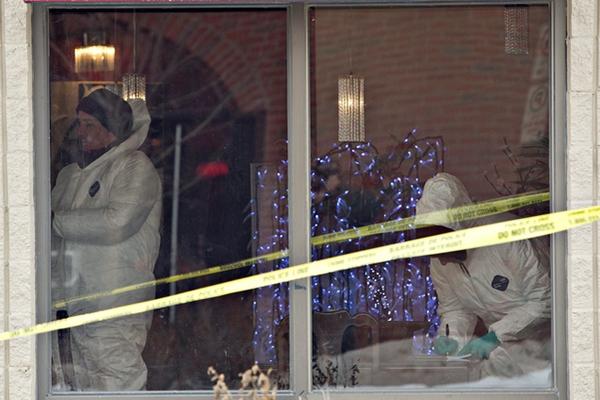 Agentes forenses recaban evidencias en la casa. (Foto Prensa Libre: AP)