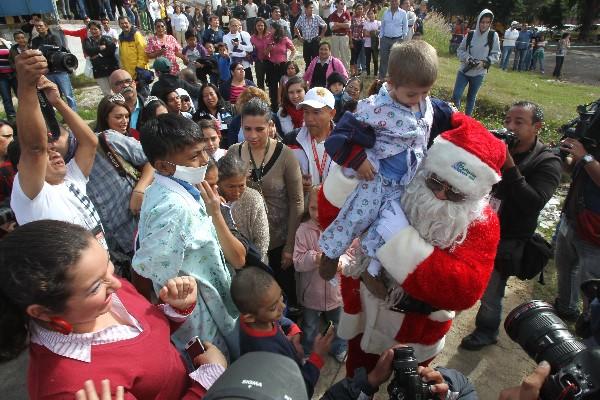 Ricardo Contreras, vestido como Santa Claus, abraza a uno de los niños internos en el Hospital San Juan de Dios.