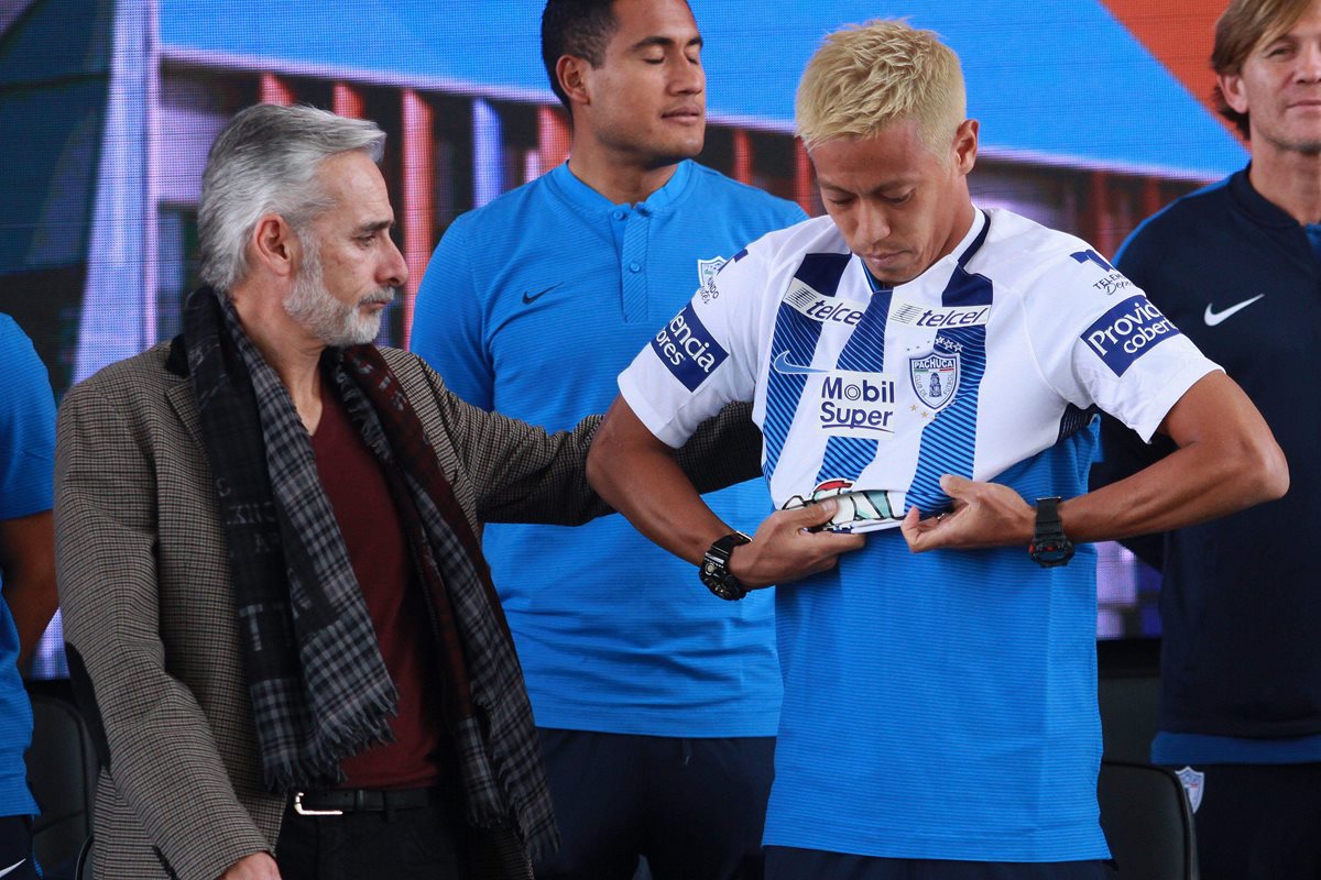 El japonés Keisuke Honda se viste con la camisola del Pachuca y le ayuda el presidente del equipo mexicano, Jesús Martínez. (Foto Prensa Libre: AP)