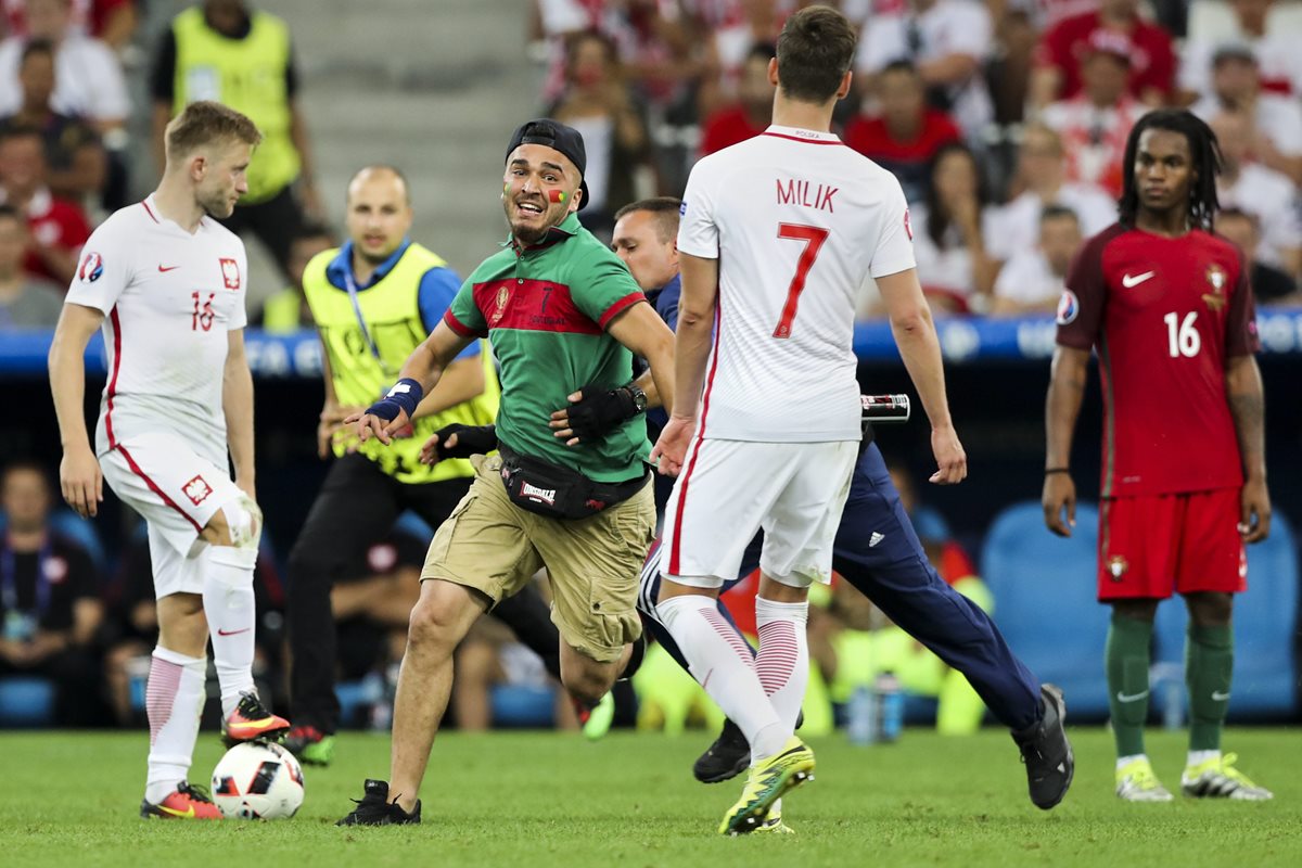 Un aficionado corre dentro del estadio durante el desarrollo del juego Portugal contra Polonia. (Foto Prensa Libre: EFE).
