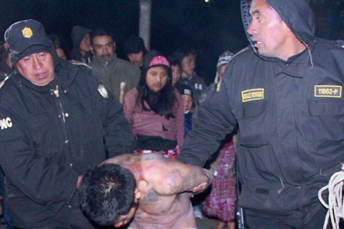 Agentes policiales  llevan a hombre vapuleado por pobladores de Totonicapán. (Foto Prensa Libre: Édgar Domínguez)