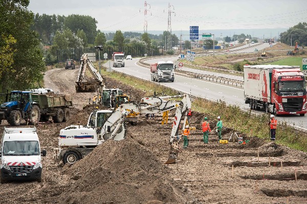 Los trabajadores cavan cimientos de un muro en una carretera que conduce al puerto de Calais. (Foto Prensa Libre: AFP)
