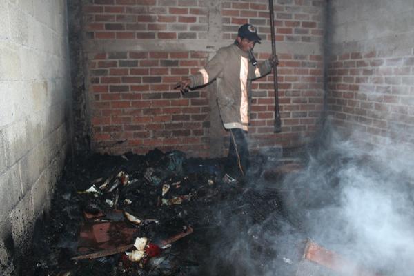 Un bombero remueve escombros en uno de los cuartos de la vivienda que se quemó en Jutiapa. (Foto Prensa Libre: Óscar González)<br _mce_bogus="1"/>