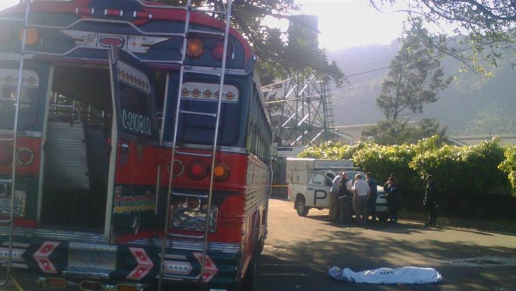 Autobús que fue tomado por asalto en Palín; a un costado el cadáver del pasajero que murió baleado. (Foto Prensa Libre: Enrique Paredes).