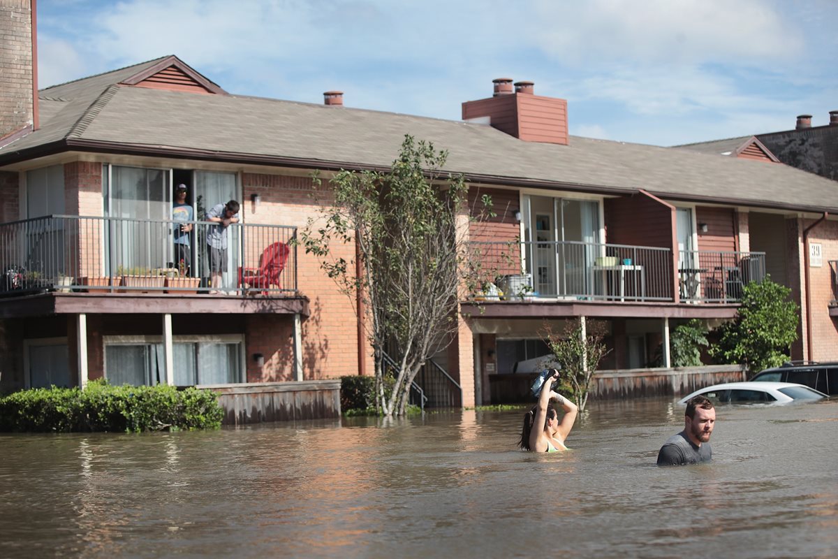 Residentes de Houston, Texas, esperan ser rescatados tras el paso de la tormenta Harvey. (Foto Prensa Libre: AFP)