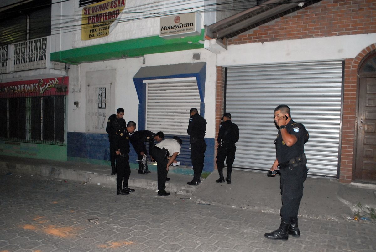 Agentes policiales recaban evidencias en cercanías de la agencia bancaria robada, en Sanarate, El Progreso. (Foto Prensa Libre: Hugo Oliva)