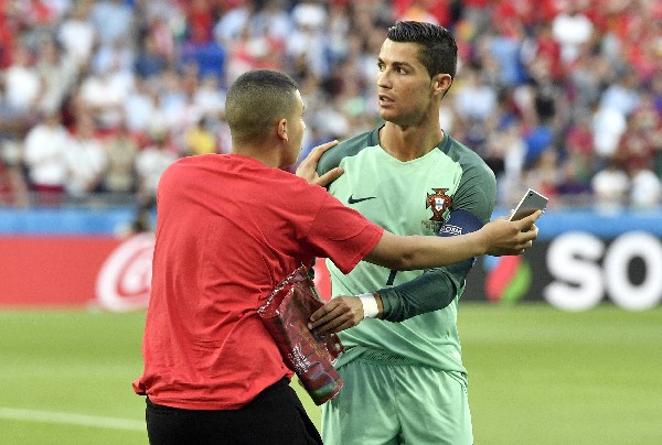 Cristiano Ronaldo fue seguido en el juego de ayer contra Gales por un voluntario en el estadio. (Foto Prensa Libre: AP)