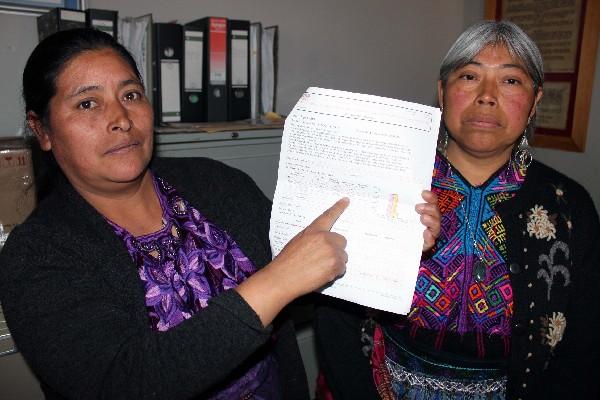 Delia Méndez muestra el  documento.