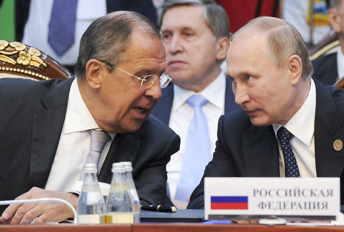 El canciller ruso Sergey Lavrov (i) conversa con el presidente Vladimir Putin (d). Foto Prensa Libre: AP