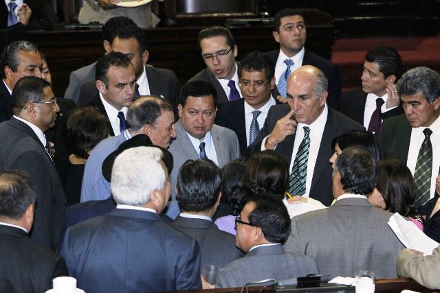 Jefes de bloques se reúnen al centro del hemiciclo para lograr acuerdos sobre suspender la aprobación de la ley para el fortalecimiento de la SAT. (Foto Prensa Libre: Paulo Raquec)