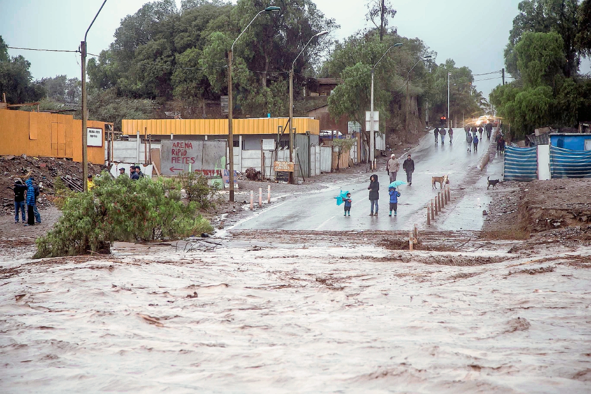 La gente observa el desbordamiento del río Copiapó, debido a la lluvia que afectó a algunas zonas de Copiapó, Chile (Foto Prensa Libre:AFP)