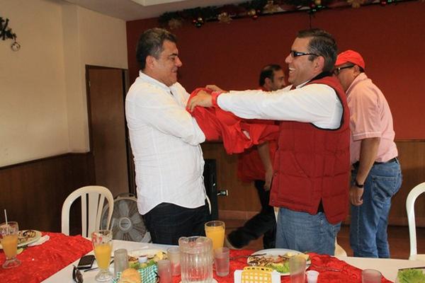 Hernán Morán, diputado por Escuintla, se coloca la camisa roja con la ayuda de Manuel Baldizón de Líder. (Foto Prensa Libre: Enrique Paredes)