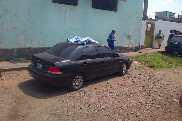 El cadáver baleado de Luis Carlos Vásquez quedó en el interior de su vehículo, en Santa Lucía Cotzumalguapa. (Foto Prensa Libre: Enrique Paredes) 