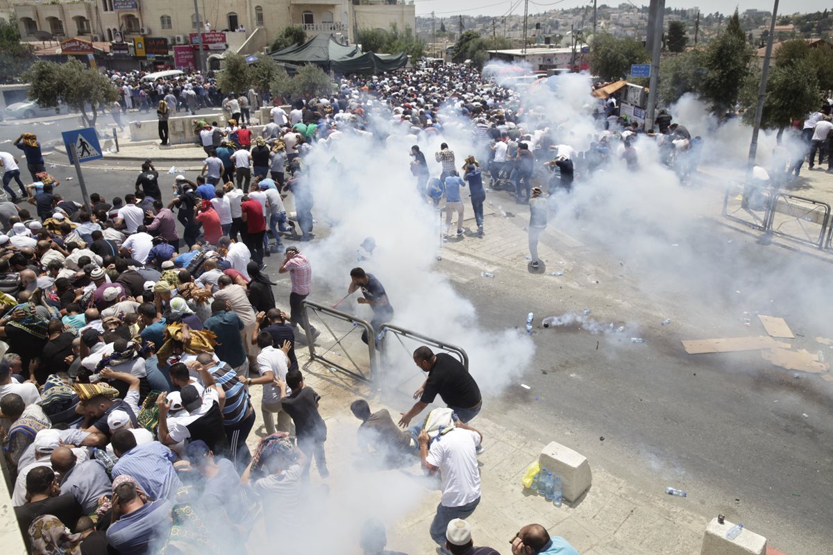 Los palestinos huyen de los gases lacrimógenos lanzados por la policía israelí fuera de la Ciudad Vieja de Jerusalén. (Foto Prensa Libre: AP).