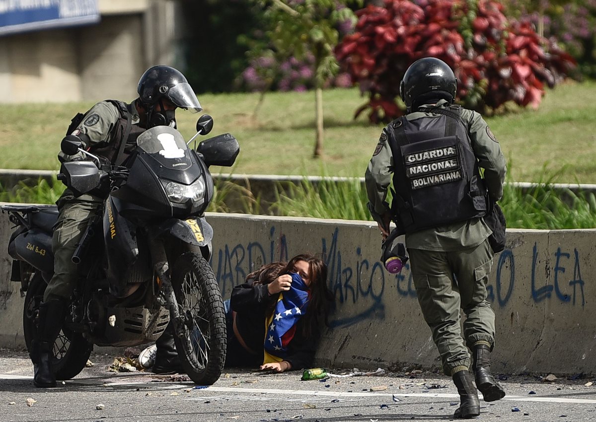 Efectivos arrestan a una manifestante en Caracas, Venezuela. (Foto Prensa Libre: AFP)