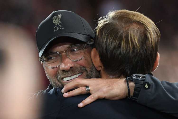 Jürgen Klopp, técnico del Liverpool, se saluda con Thomas Tuchel, entrenador del PSG. (Foto Prensa Libre: AFP)