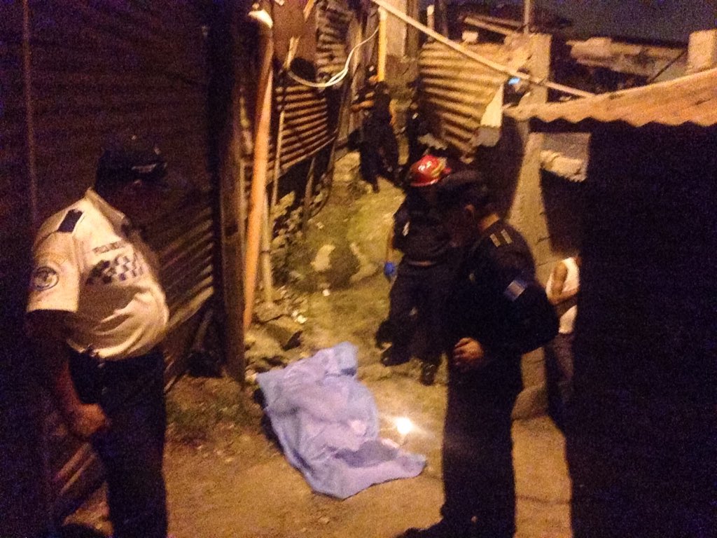 Bomberos y policías alrededor del cadáver de un hombre, muerto a balazos en Villalobos, zona 12 de Villa Nueva. (Foto Prensa Libre: CBM)