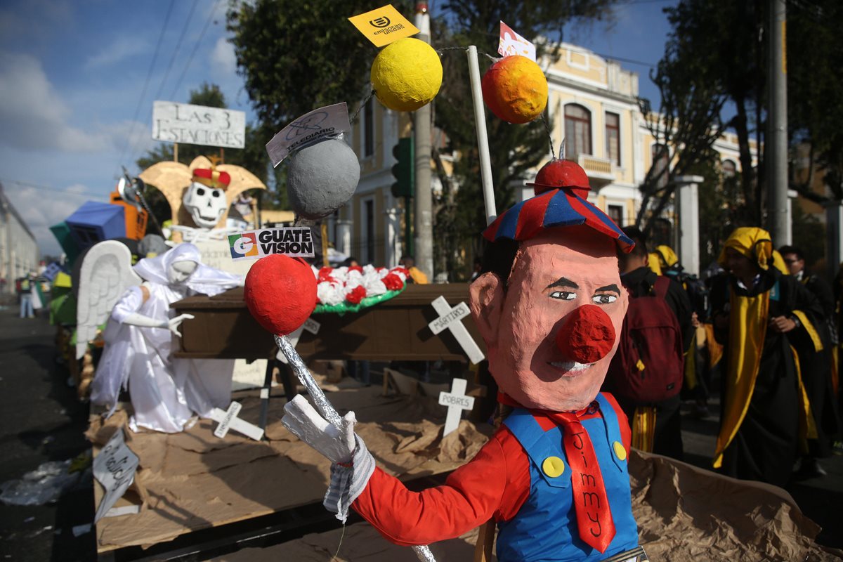 Muñecos vestidos de payaso que simulan al presidente Morales, pancartas del muro que prevé construir Estados Unidos fue parte de la mofa. (Foto Prensa Libre: EFE)