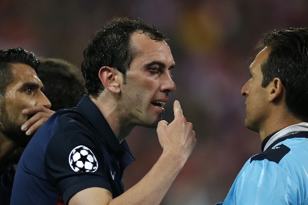 Diego Godín le reclama al árbitro por el codazo recibido por Luis Suárez, del Barcelona. (Foto Prensa Libre: AP)