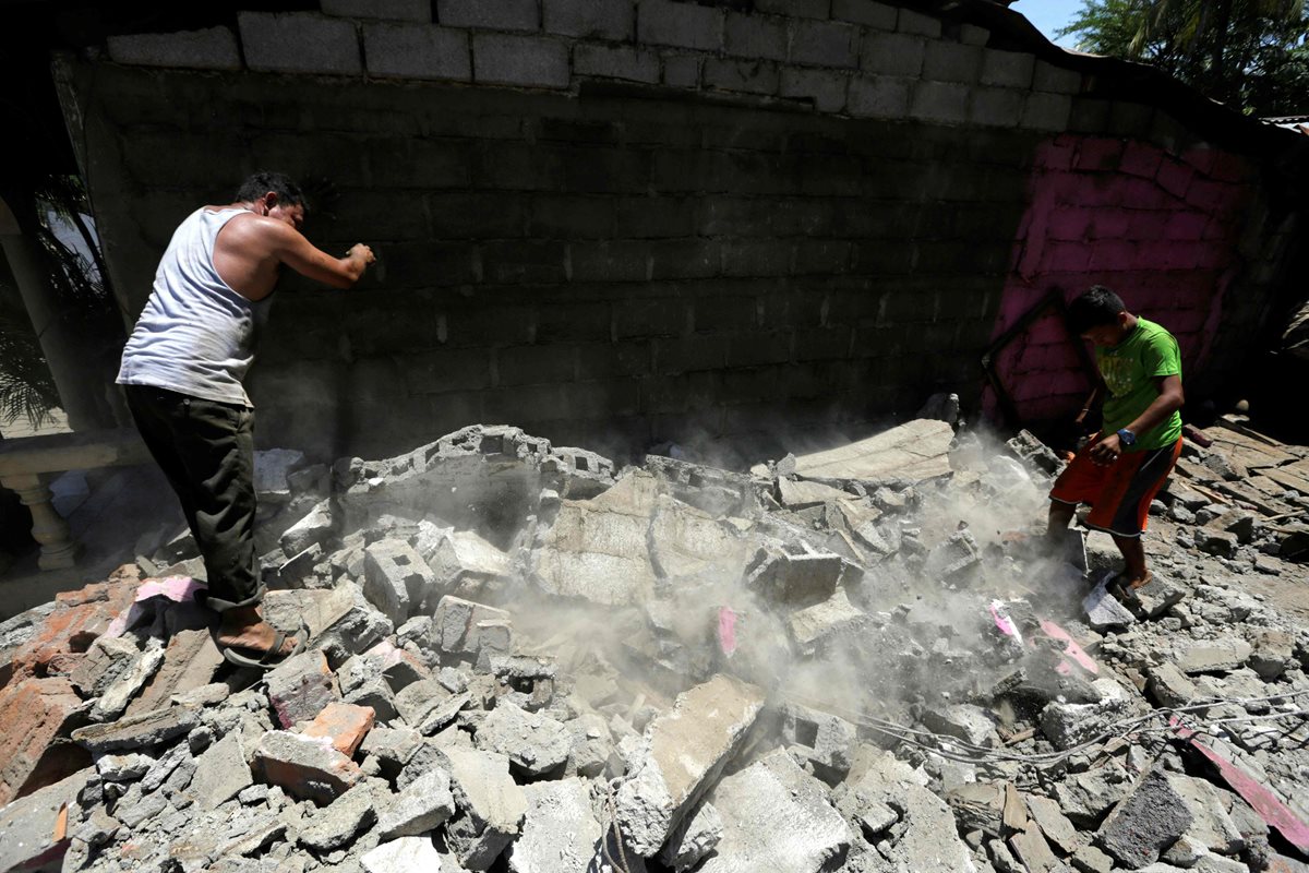 Dos habitantes de Tonalá tratan de remover los escombros de su casa, destruida. (Foto Prensa Libre: AFP).