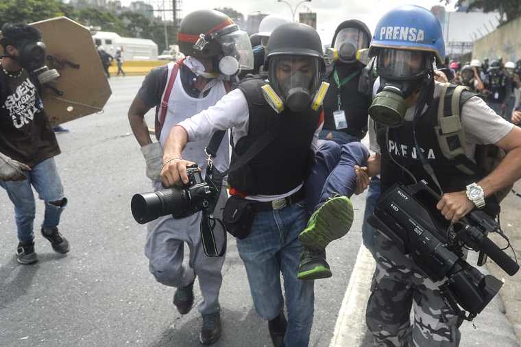 Un periodista es llevado herido por sus compañeros durante una protesta en Venezuela. (Foto: Hemeroteca PL)
