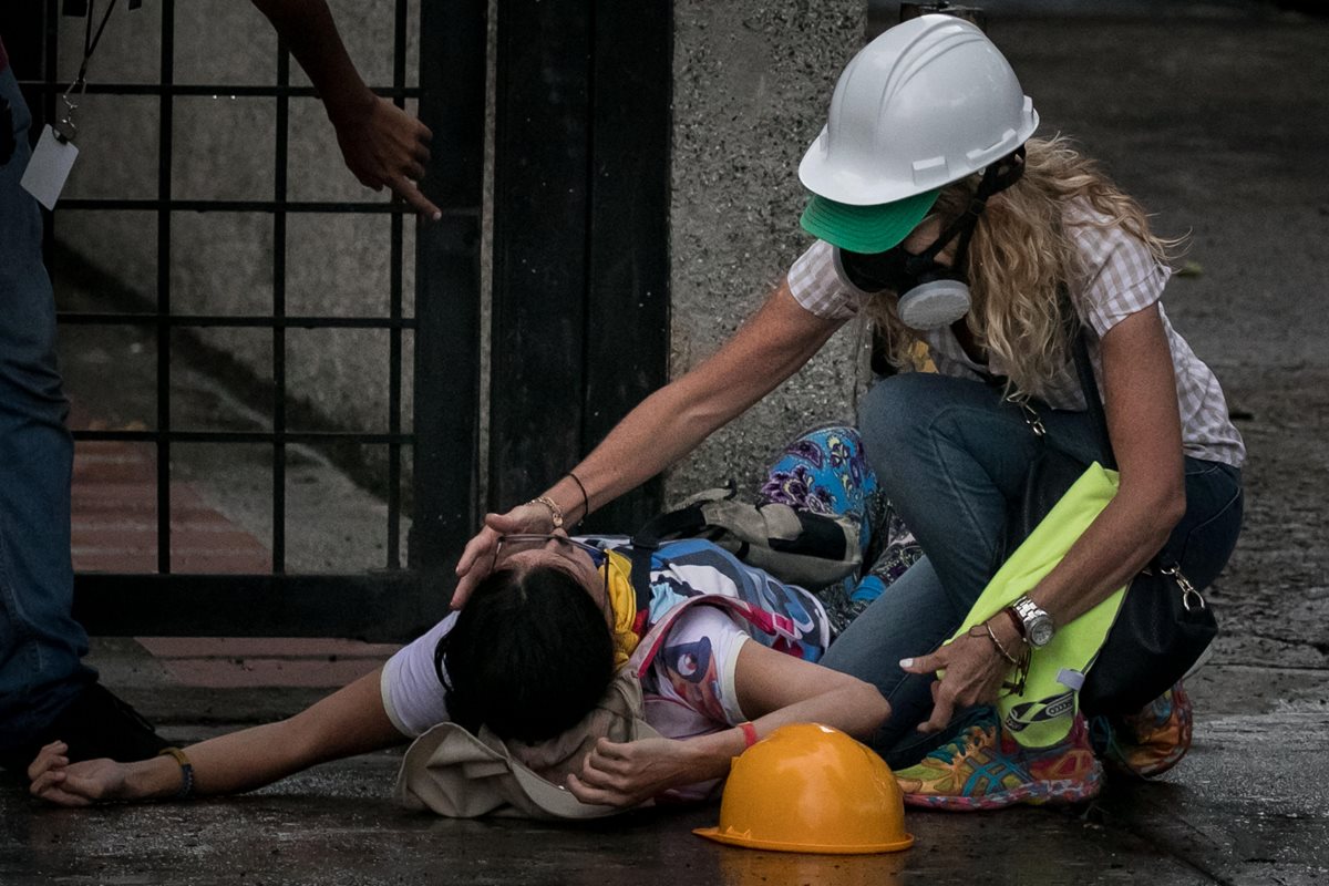 Una opositora permanece desmayada durante los enfrentamientos con la Guardia Nacional.(EFE).