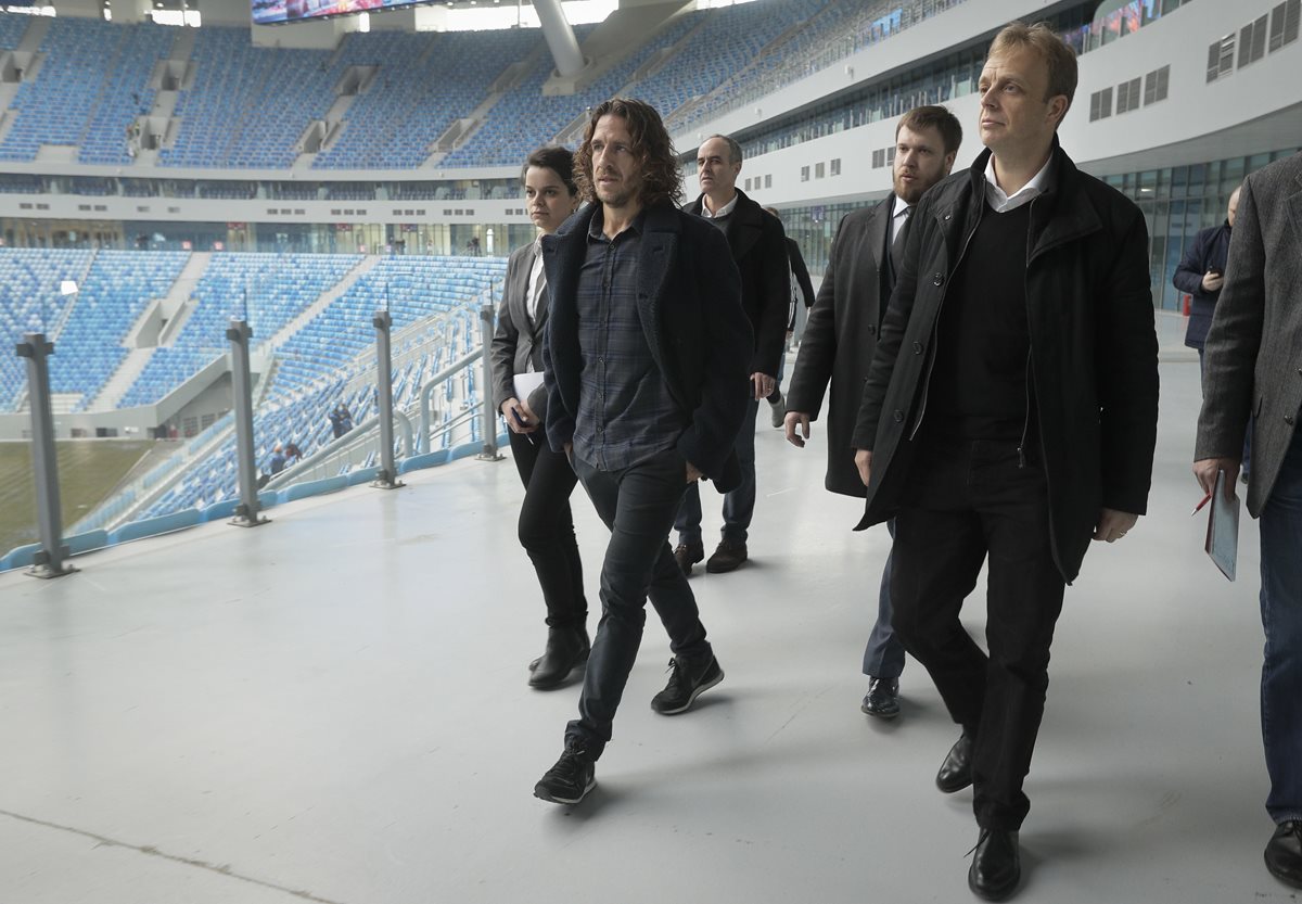 El exjugador español Carles Puyol acompaña a delegados de la Fifa a una inspección al estadio de San Petesburgo. (Foto Prensa Libre: AP)