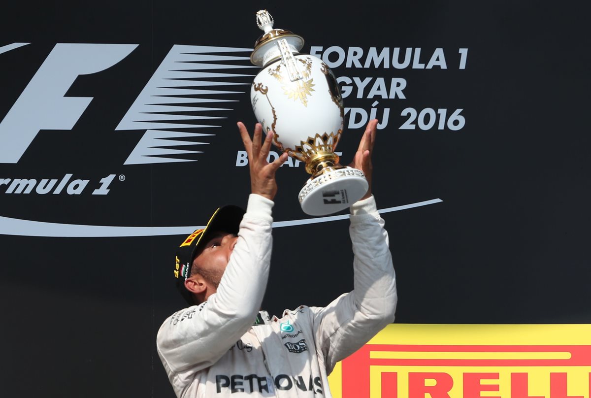 Lewis Hamilton levanta por los aires el trofeo del Gran Premio de Hungría. (Foto Prensa Libre: AFP)
