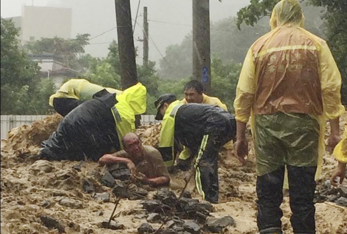 Socorristas auxilian a una persona soterrada por tifón que azota en Taiwán. (Foto Prensa Libre: AP)