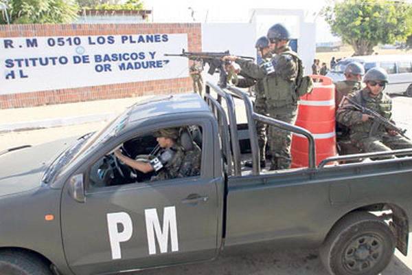 Soldados efectúan patrullajes frente a una escuela de Villa Nueva que ha sido extorsionada, en  apoyo a la PNC.