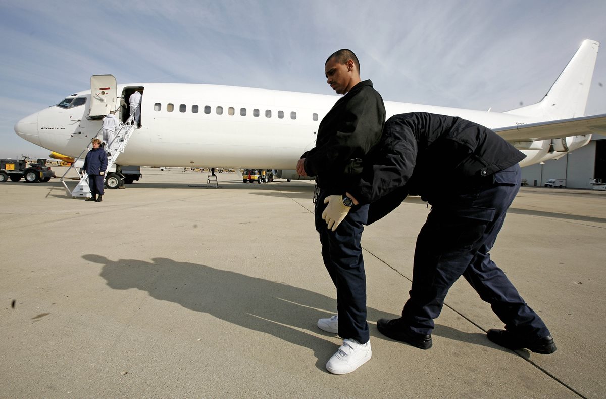 Un agente de inmigración acompaña a indocumentado antes de ser deportado en Chicago. (Foto Prensa Libre:AP).