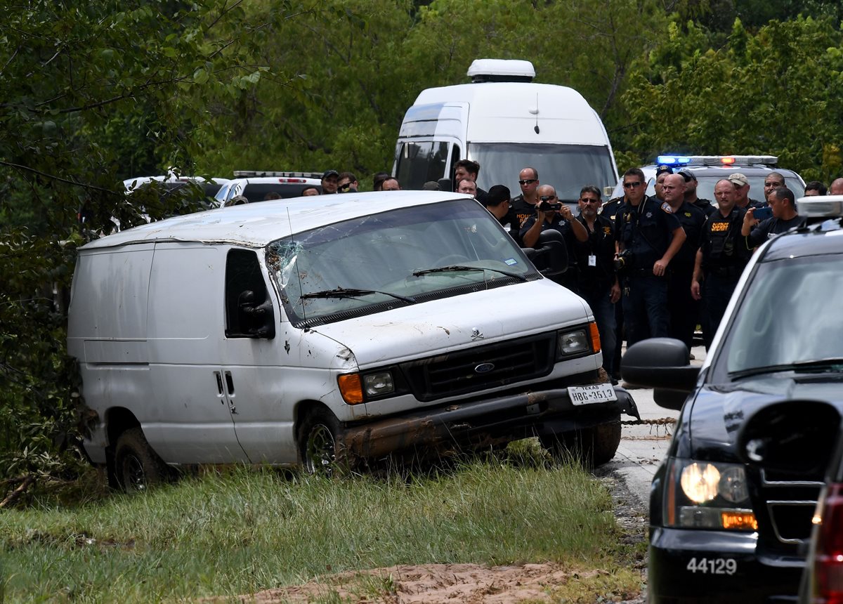 La policía retiran los cadáveres de los integrantes de la familia que murieron al caer el vehículo en un pantano.(AFP).