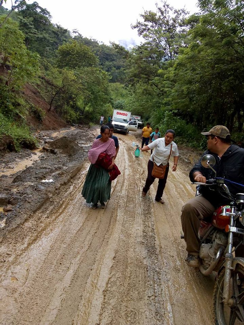 Madre corre junto a enfermera, entre el lodo, pidiendo ayuda a un motociclista para trasladar a su bebé al hospital. (Foto Prensa Libre: Eduardo Sam)