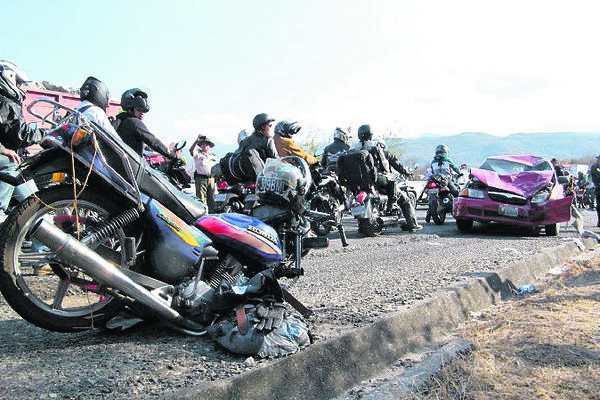 Varios motociclistas observan la escena del accidente entre una moto y un vehículo. (Foto Prensa Libre: Héctor Contreras)