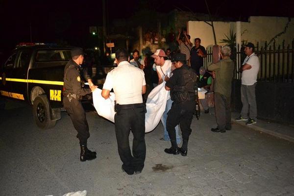 Autoridades trasladan a la morgue el cadáver de Josué Daniel Castro, quien murió baleado, en Sanarate. (Foto Prensa Libre: Hugo Oliva)