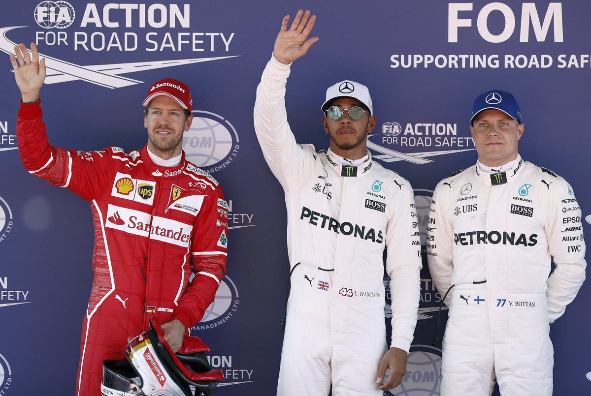 Lewis Hamilton, del equipo Mercedes, celebra la primera posición junto a su compañero de equipo el piloto finlandés Valtteri Bottas y Sebastian Vettel. (Foto Prensa Libre: EFE)