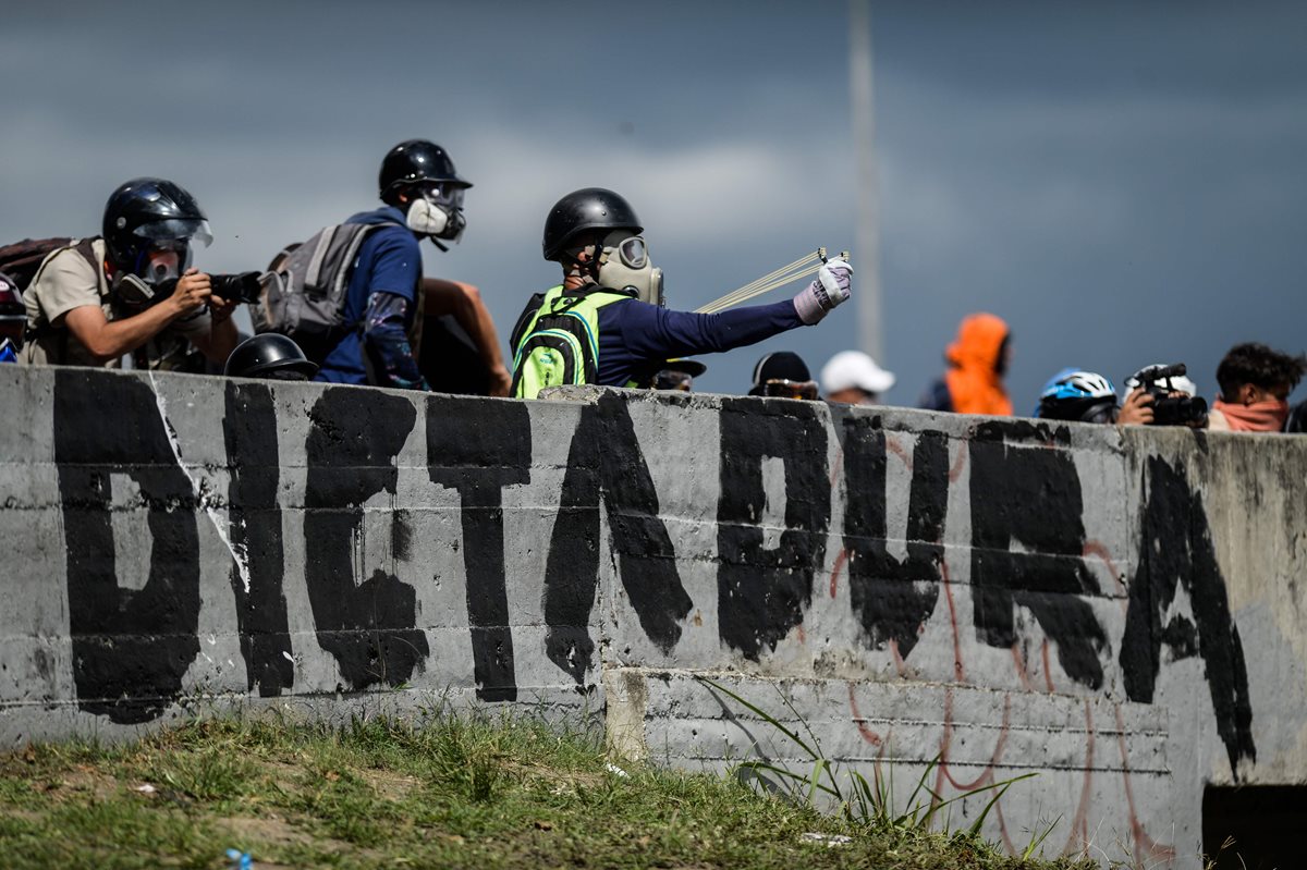 Opositores de enfrenta con la Policía antidisturbios en Caracas.(Foto Prensa Libre:AFP).