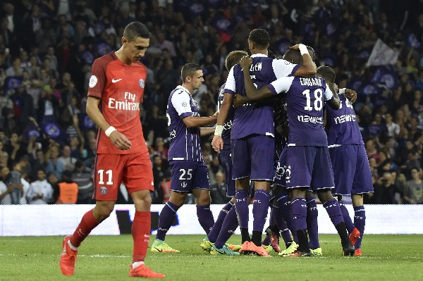 Los jugadores del Toulouse celebran, mientras Ángel Di María camina decepcionado por la derrota del PSG. (Foto Prensa Libre: AFP)