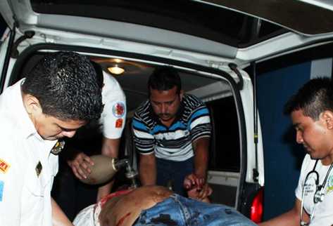 Bomberos atienden a una de las personas heridas durante la balacera de este domingo. (Foto Prensa Libre: Rolando Miranda)